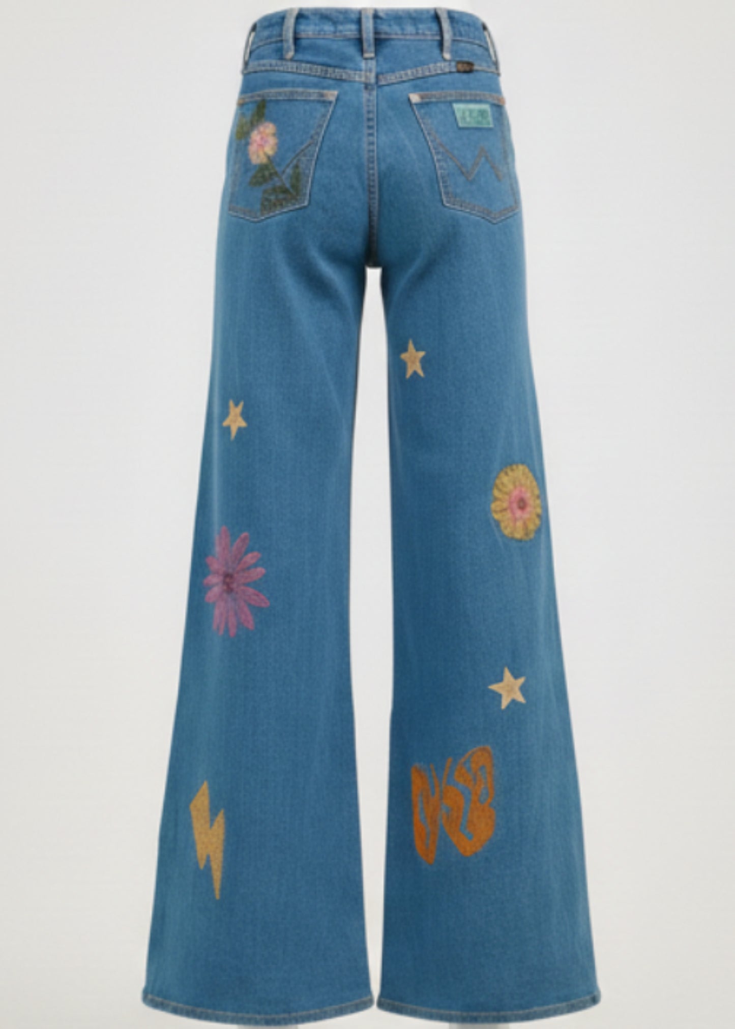 Person wearing a blue denim outfit with floral and star patterns on a plain background