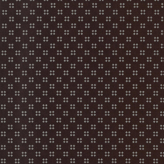 Patterned fabric with small geometric design on a brown background