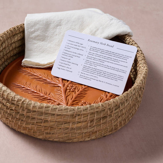 RoseMerry Bread Warmer with the included Rosemary Herb Bread recipe card and a folded white cloth