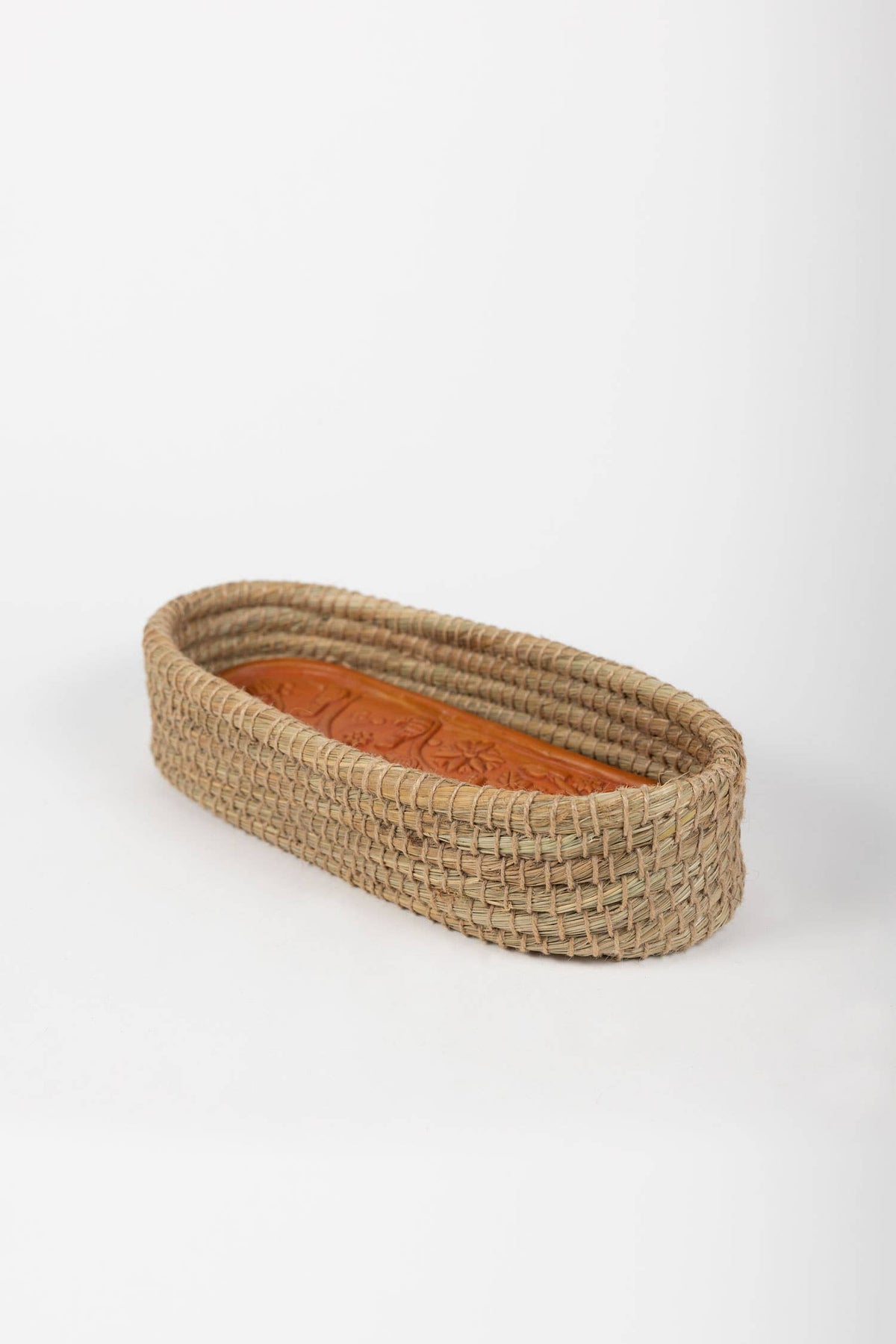 Side view of the Toasty Long Bread Basket showing its elongated woven shape and terracotta warming insert
