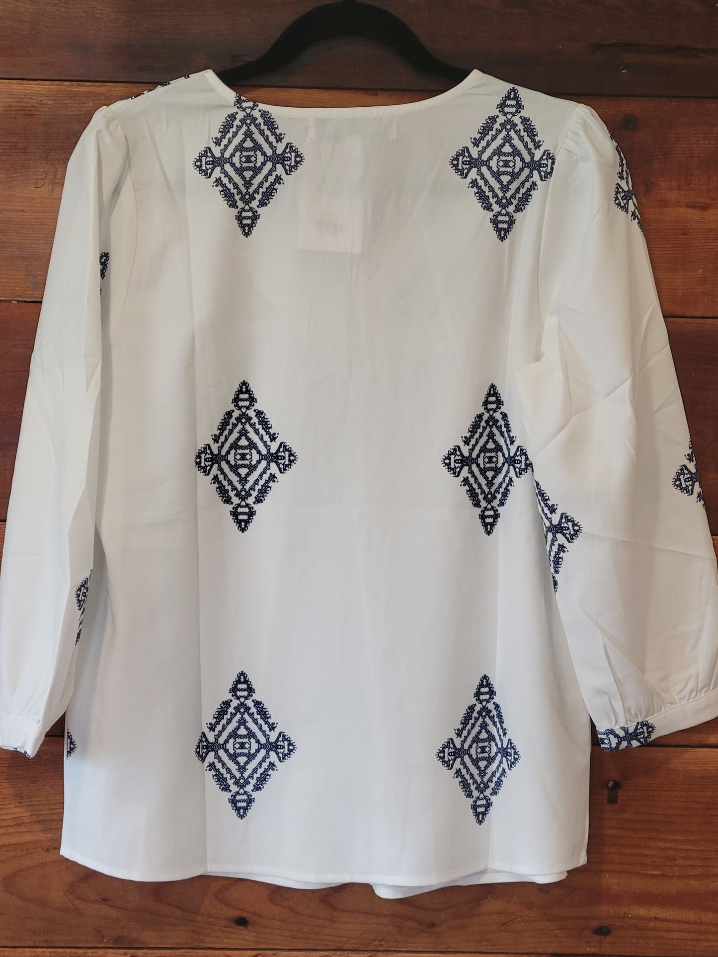 White fabric with blue geometric patterns on a wooden surface