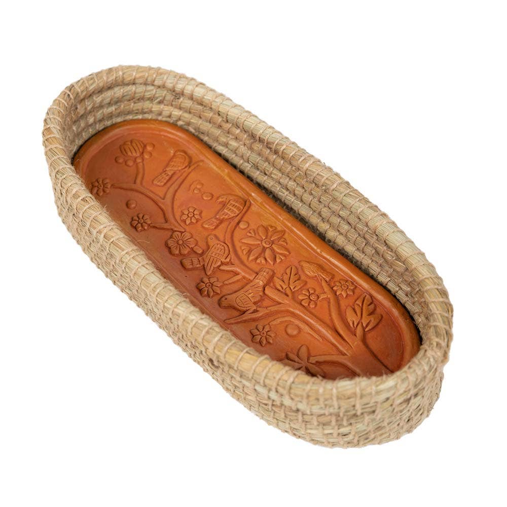 Toasty Long Bread Basket with a bird-and-flower patterned terracotta warming insert inside a natural woven basket