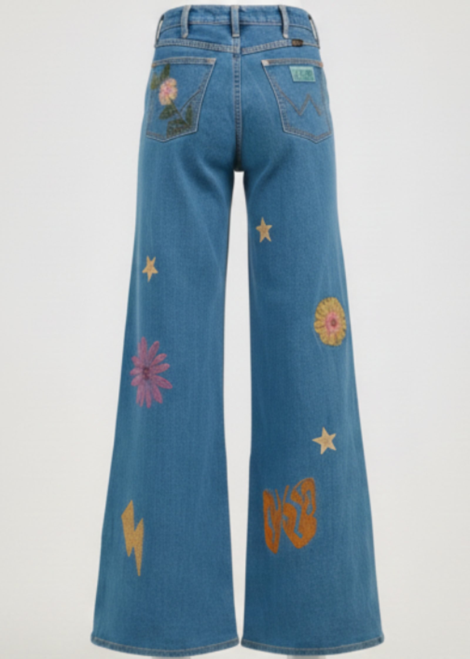 Person wearing a blue denim outfit with floral and star patterns on a plain background