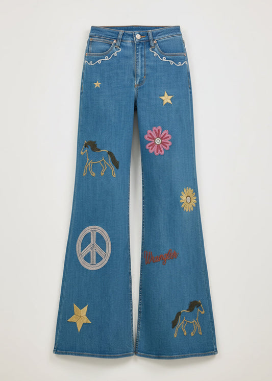 Person wearing a denim outfit with embroidered designs on a plain background