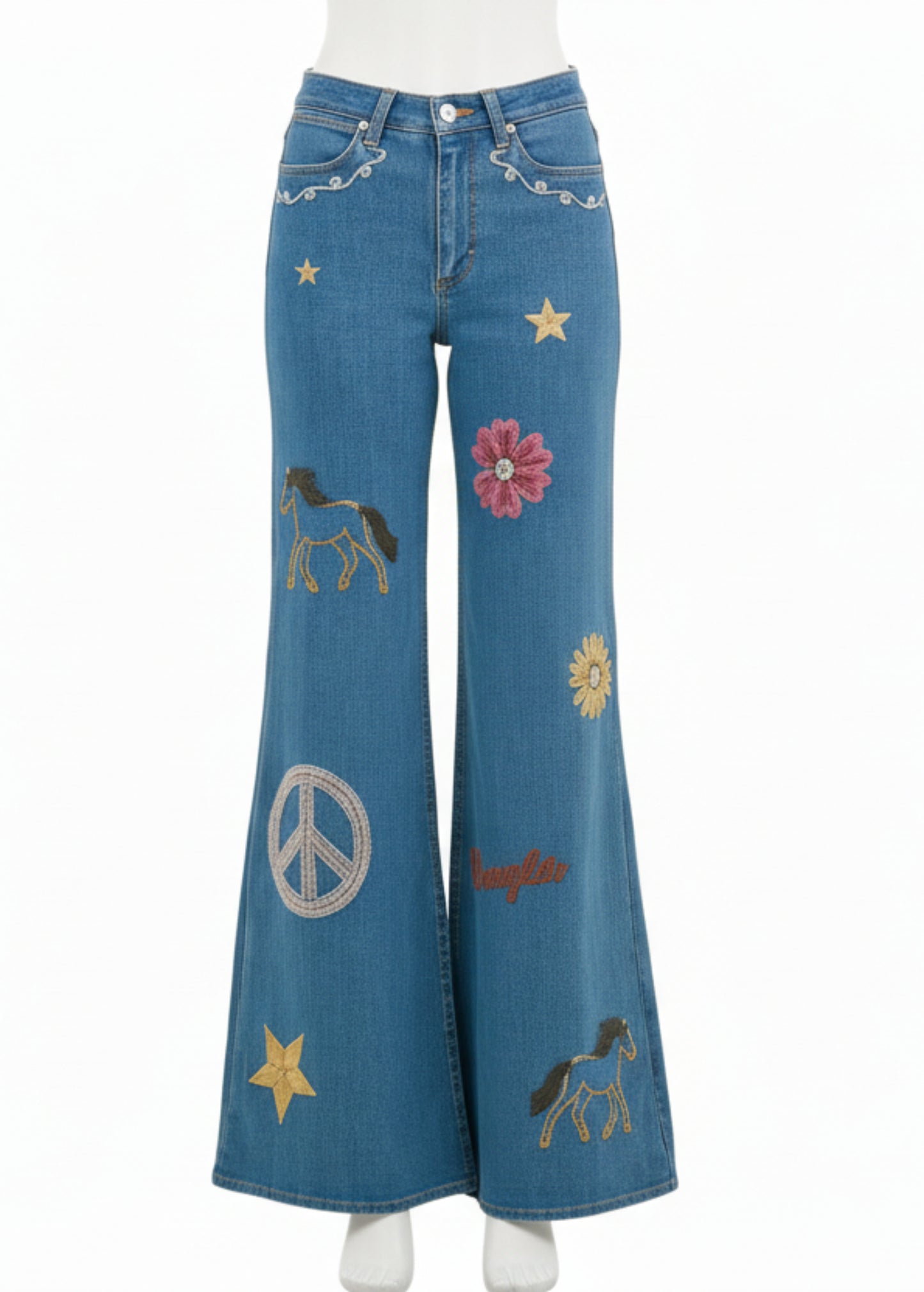 Person wearing a denim outfit with embroidered designs on a white background