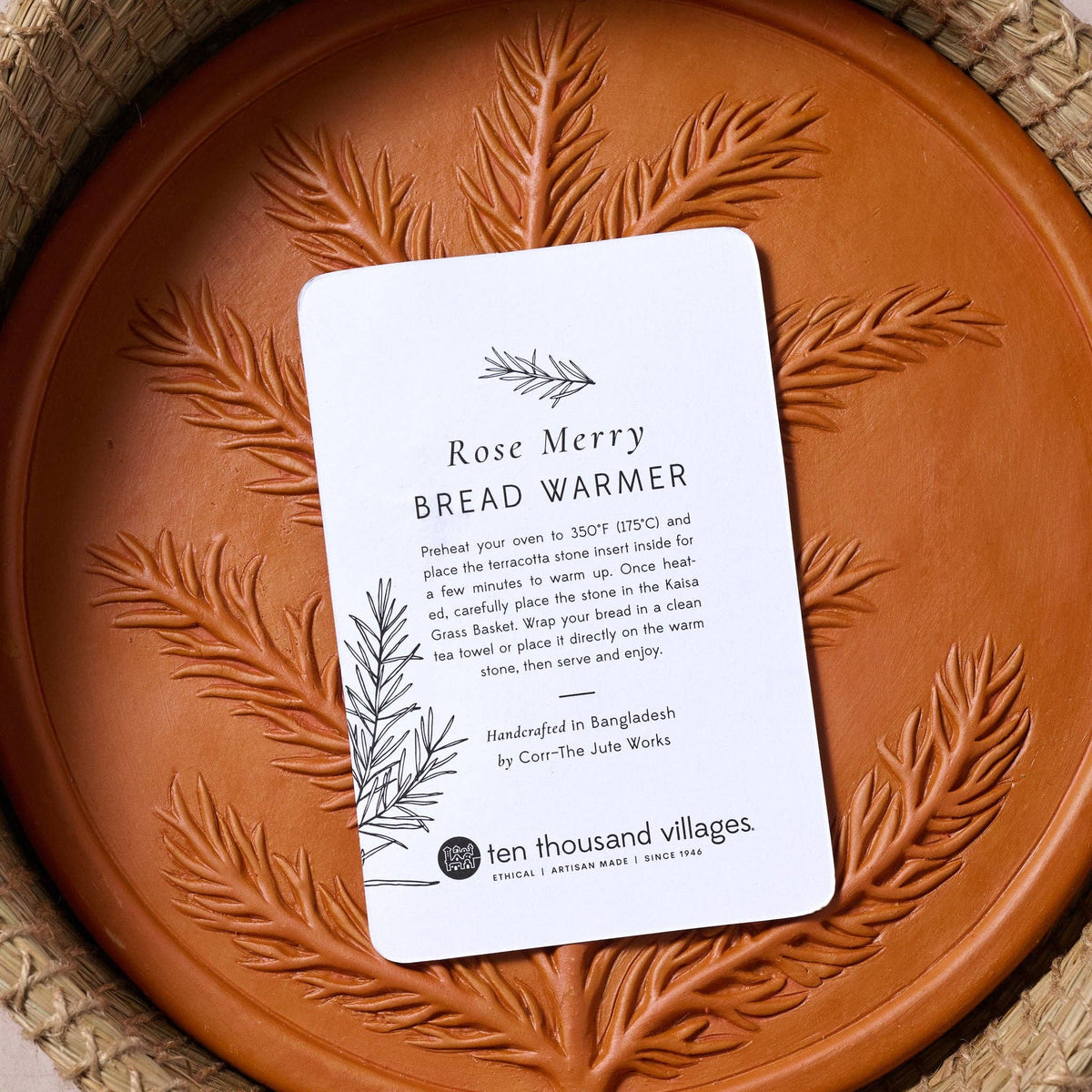 RoseMerry Bread Warmer instruction card resting on the botanical-patterned terracotta stone