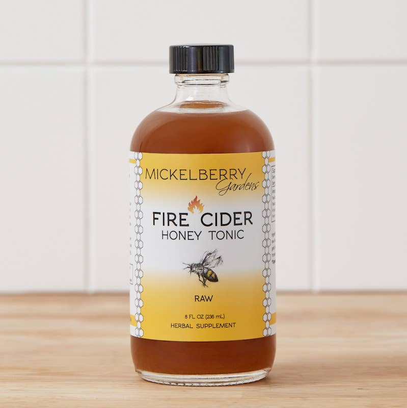 Mickelberry Gardens Fire Cider Honey Tonic glass bottle with amber-colored tonic, yellow label, and black cap