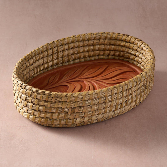 Angled view of the Gama Oval Leaf Bread Warmer with its terracotta leaf-patterned insert and oval woven basket