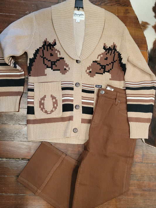 Beige sweater with horse design on a wooden surface