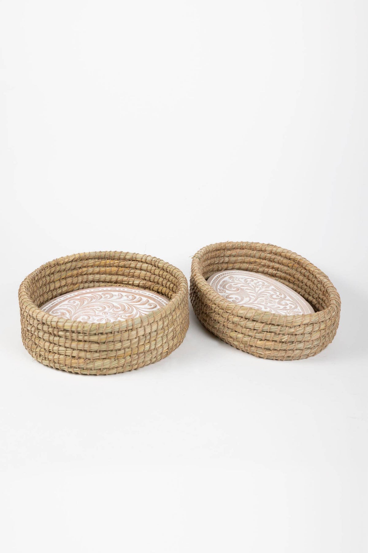 Round and oval Toasty bread baskets displayed together with whitewashed floral-patterned terracotta warming inserts