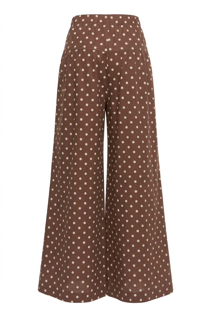 Back view of brown wide leg pants with cream polka dots and a relaxed silhouette.