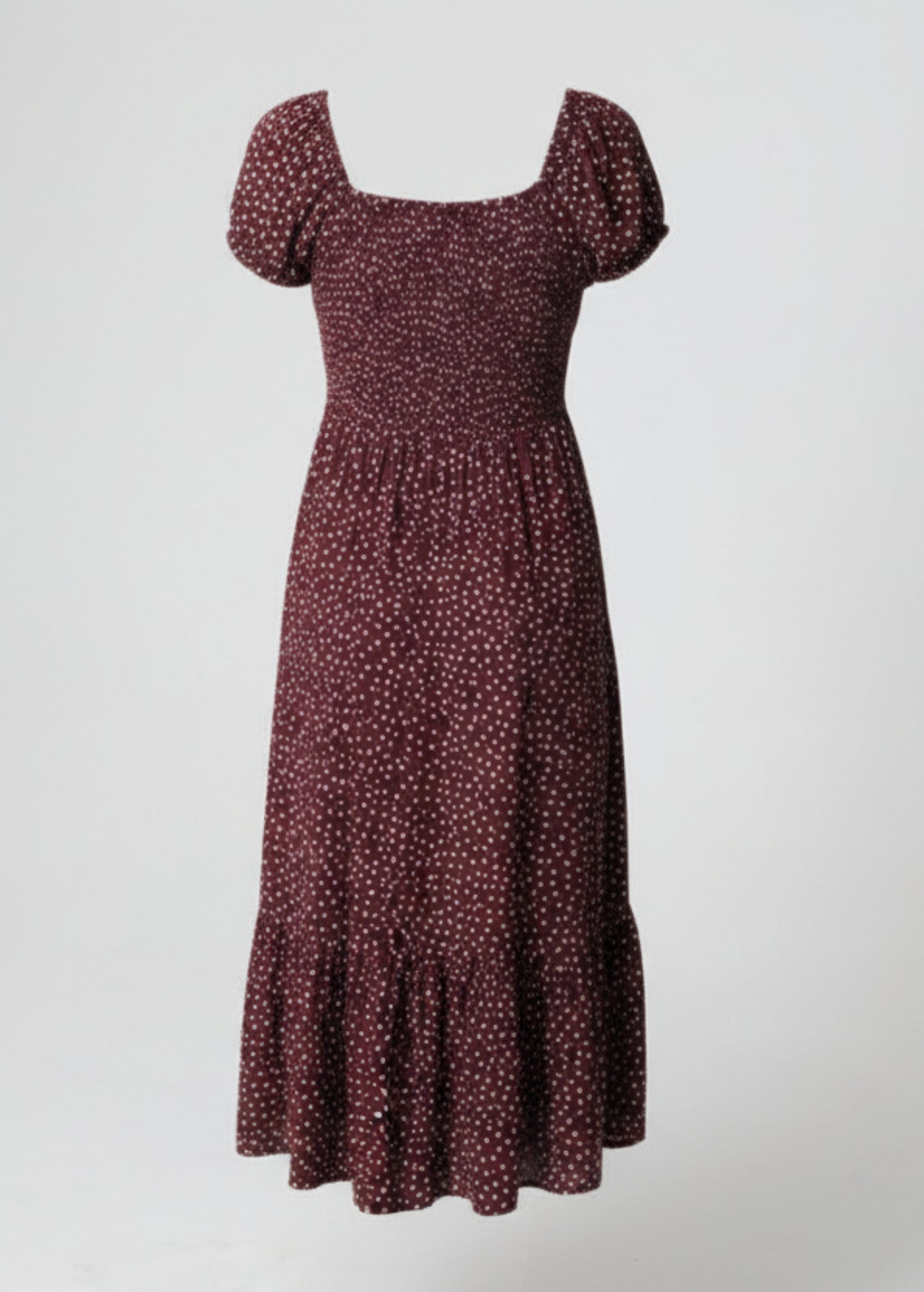 Woman wearing a polka dot dress on a plain background