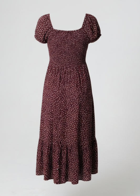 Woman wearing a polka dot dress on a plain background