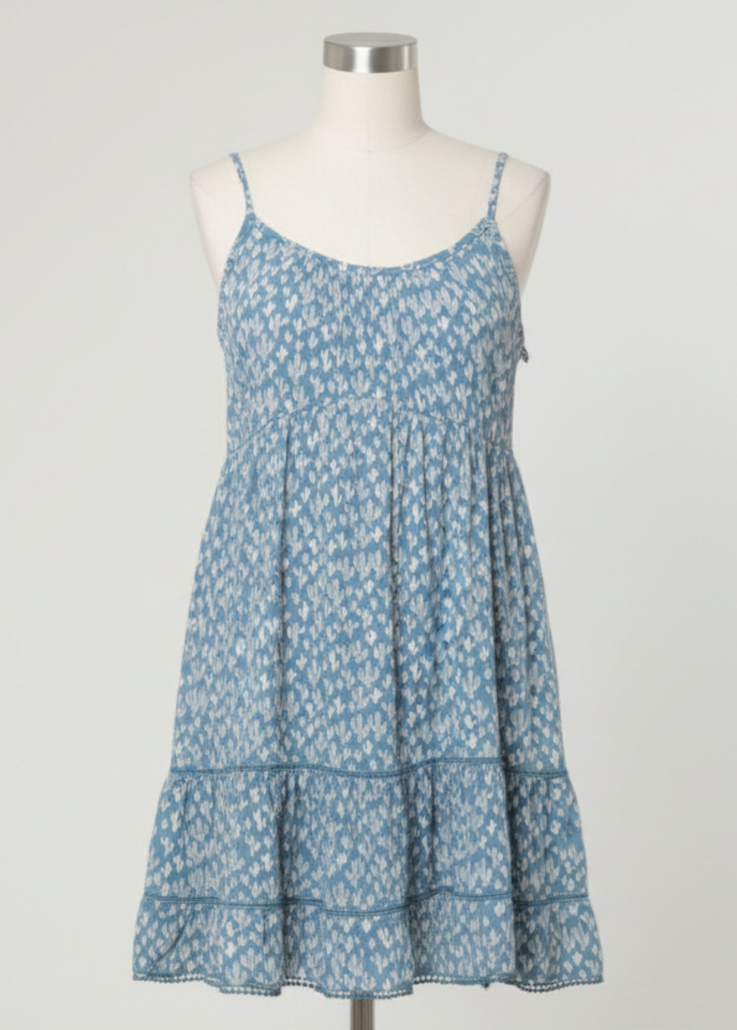 Woman wearing a blue floral dress against a gray background
