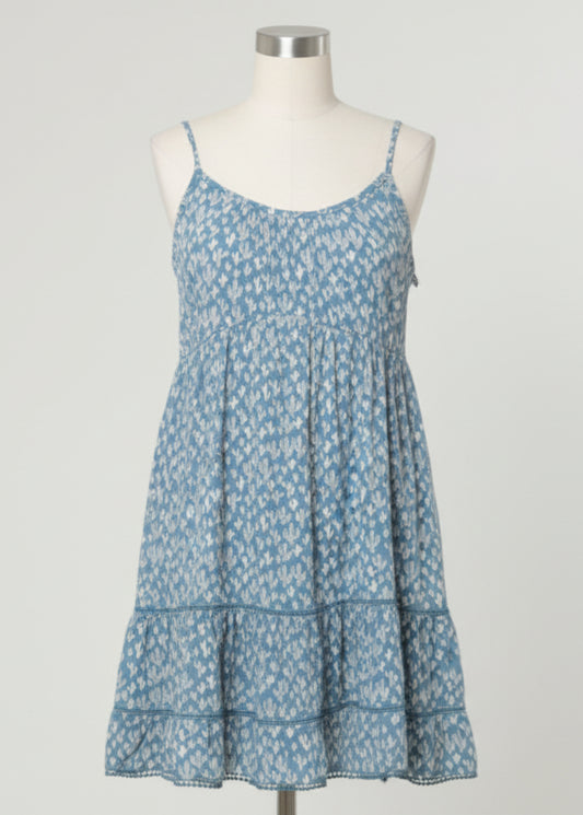 Woman wearing a blue floral dress against a gray background