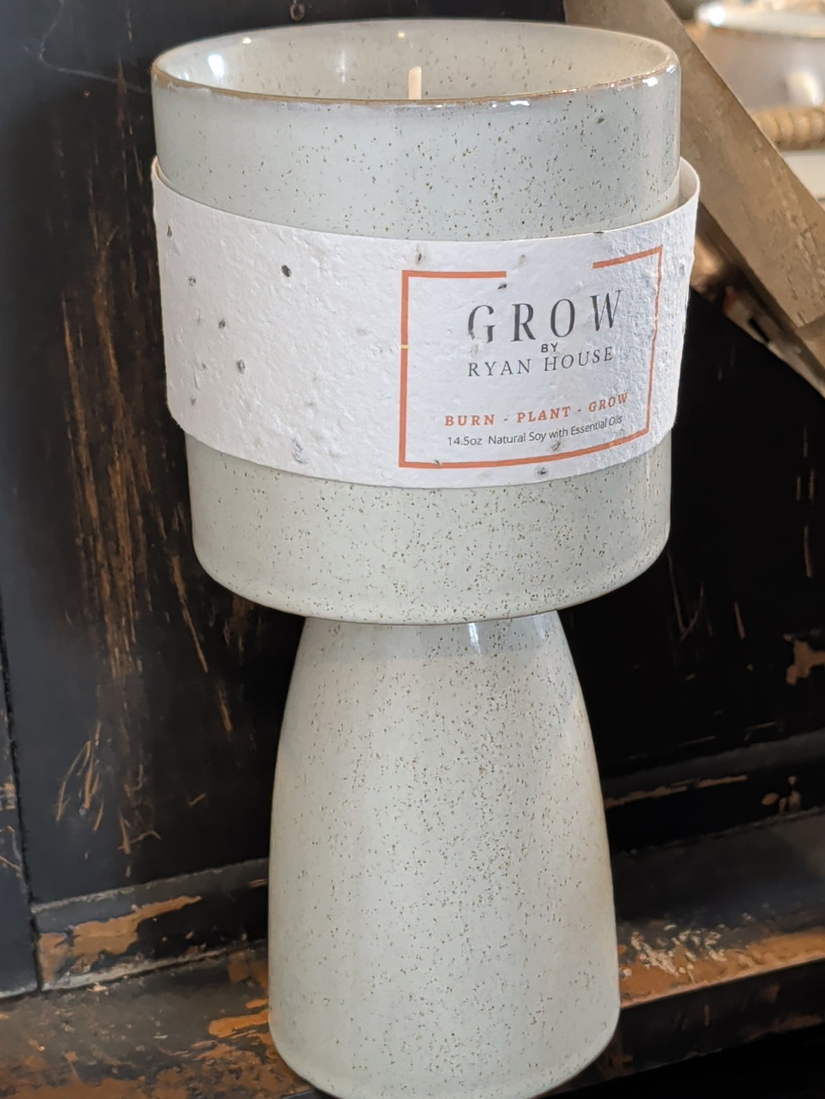 Angled view of Ryan House Stockyards Candle showing the speckled ivory vessel, pedestal base, and wick
