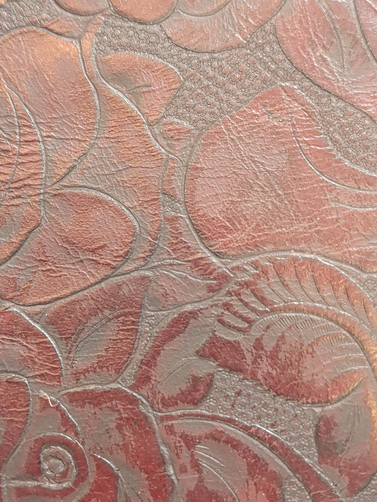Brown leather journal cover with an embossed rose design