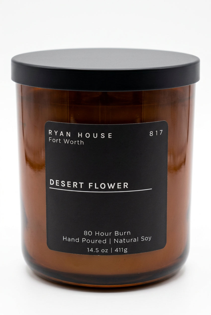 Ryan House Desert Flower soy candle in an amber glass jar with a black lid and charcoal label showing 14.5 oz.