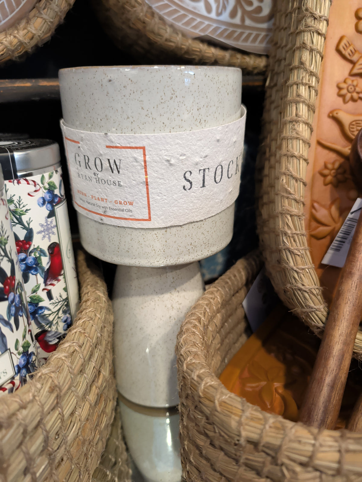 Ryan House Stockyards Candle in a speckled ivory pedestal vessel displayed between woven baskets