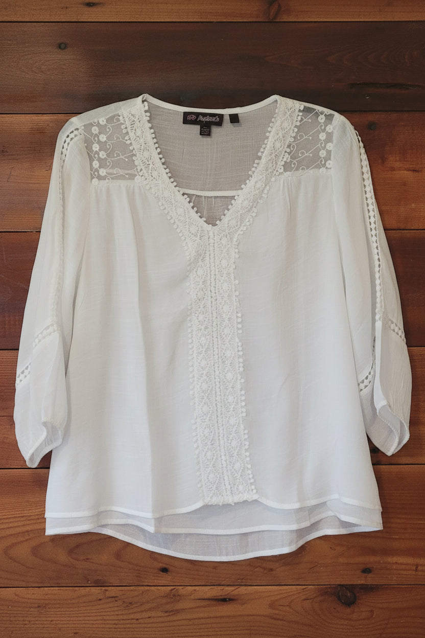 White blouse with lace details on a wooden surface