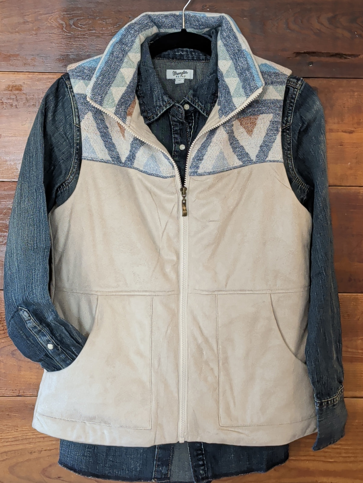 Wrangler blue denim snap shirt layered beneath a cream zip-front vest with a blue and tan geometric patterned yoke.