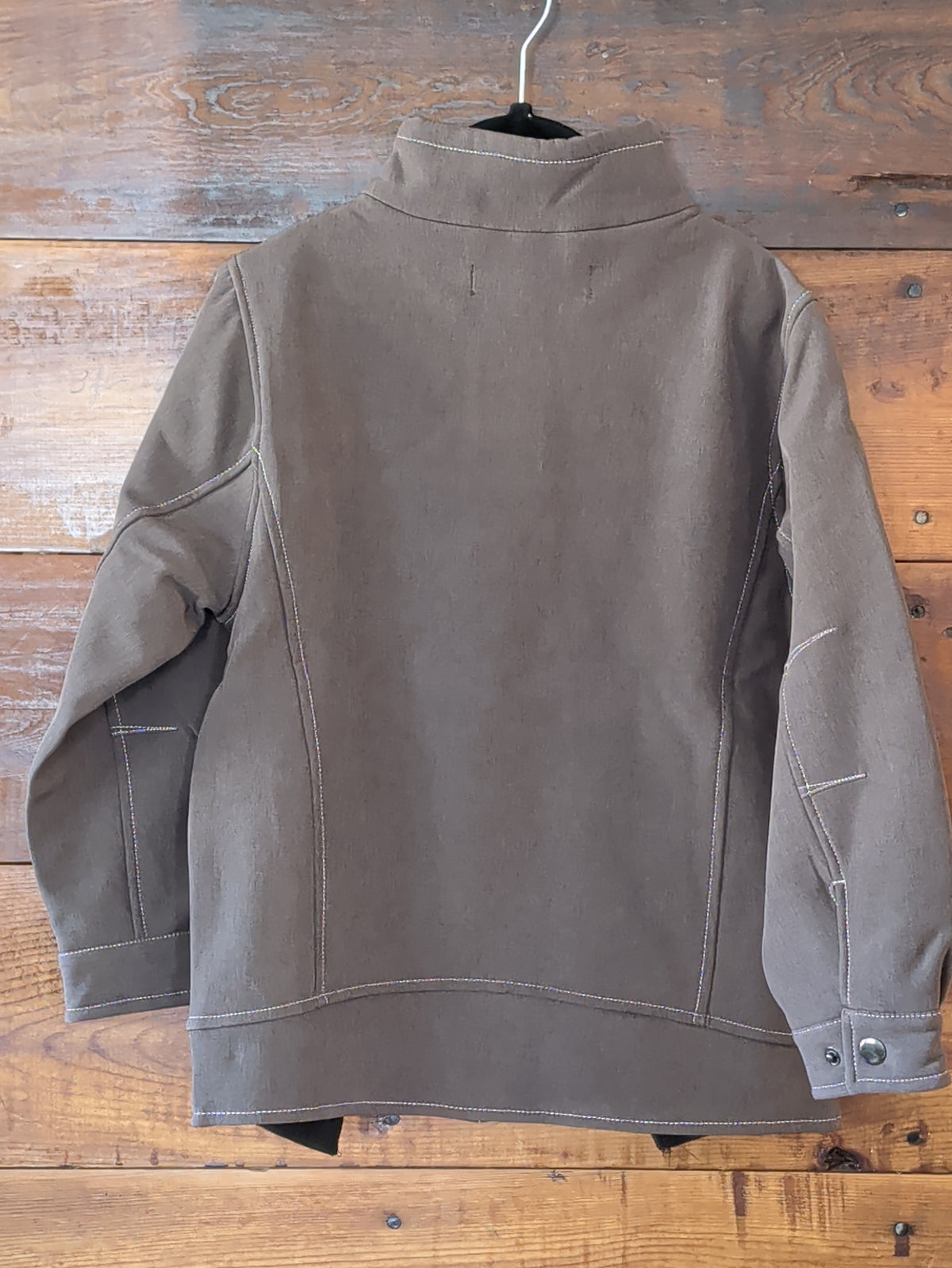 Back view of the boys brown softshell jacket showing paneled seams, long sleeves, and contrast stitching