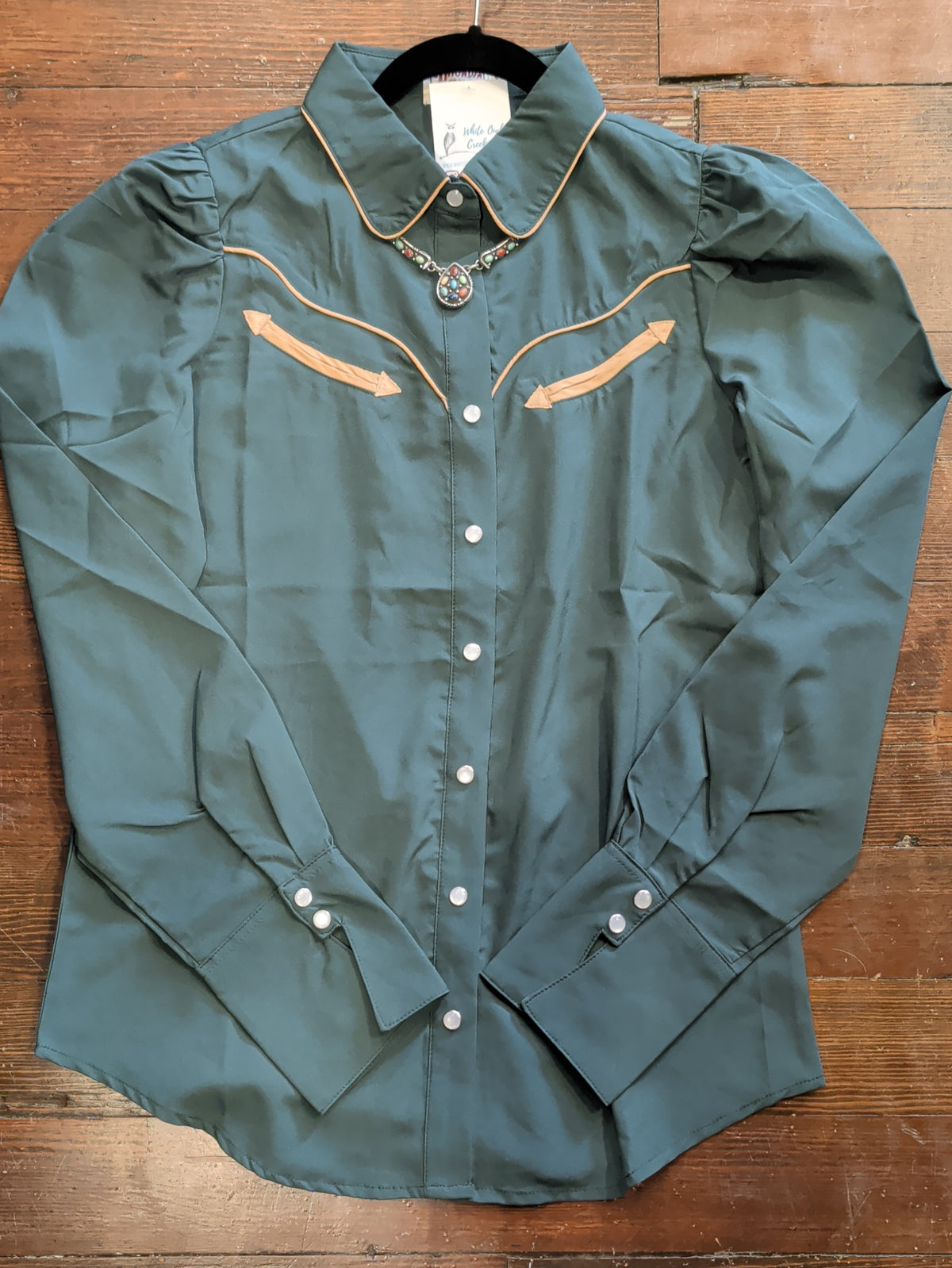 Front view of forest green pearl snap shirt with contrast collar and Western yoke piping, gathered shoulders, and long snap-cuff sleeves.