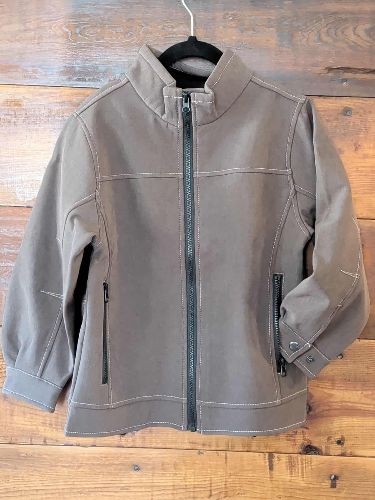 Boys brown softshell jacket with a stand collar, full-zip front, contrast stitching, and zippered pockets