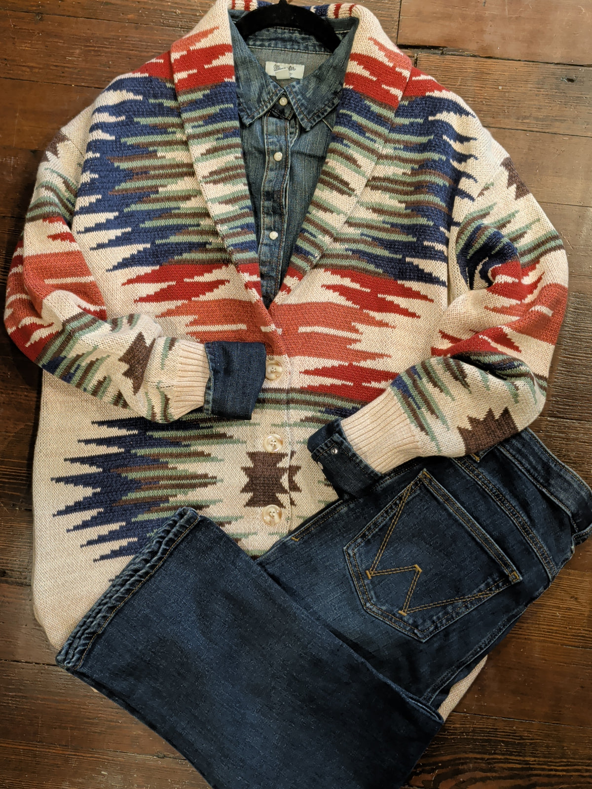 Cream Southwestern button-front cardigan styled with a denim shirt and dark-wash jeans, showing rib-knit cuffs and patterned sleeves.