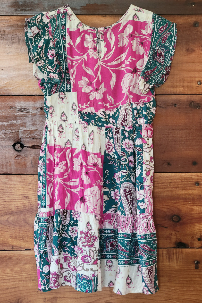 Colorful patchwork dress on a wooden surface