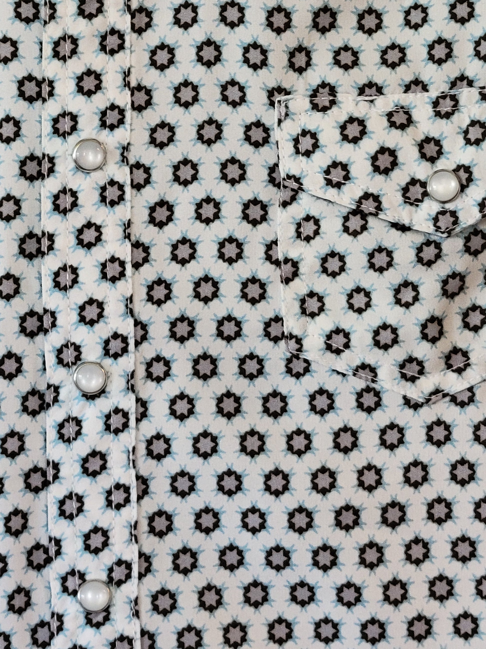 Close-up of a patterned fabric with star shapes and snaps.