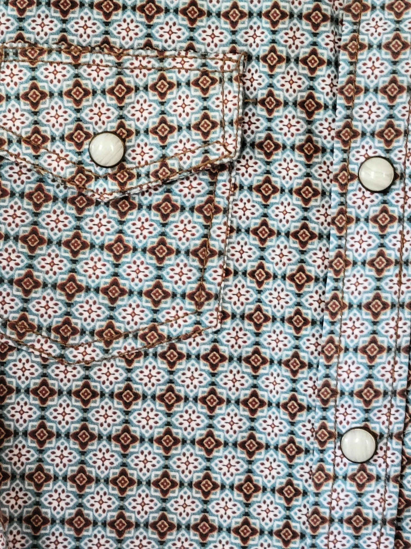 Patterned fabric with a geometric design featuring brown, white, and blue colors.