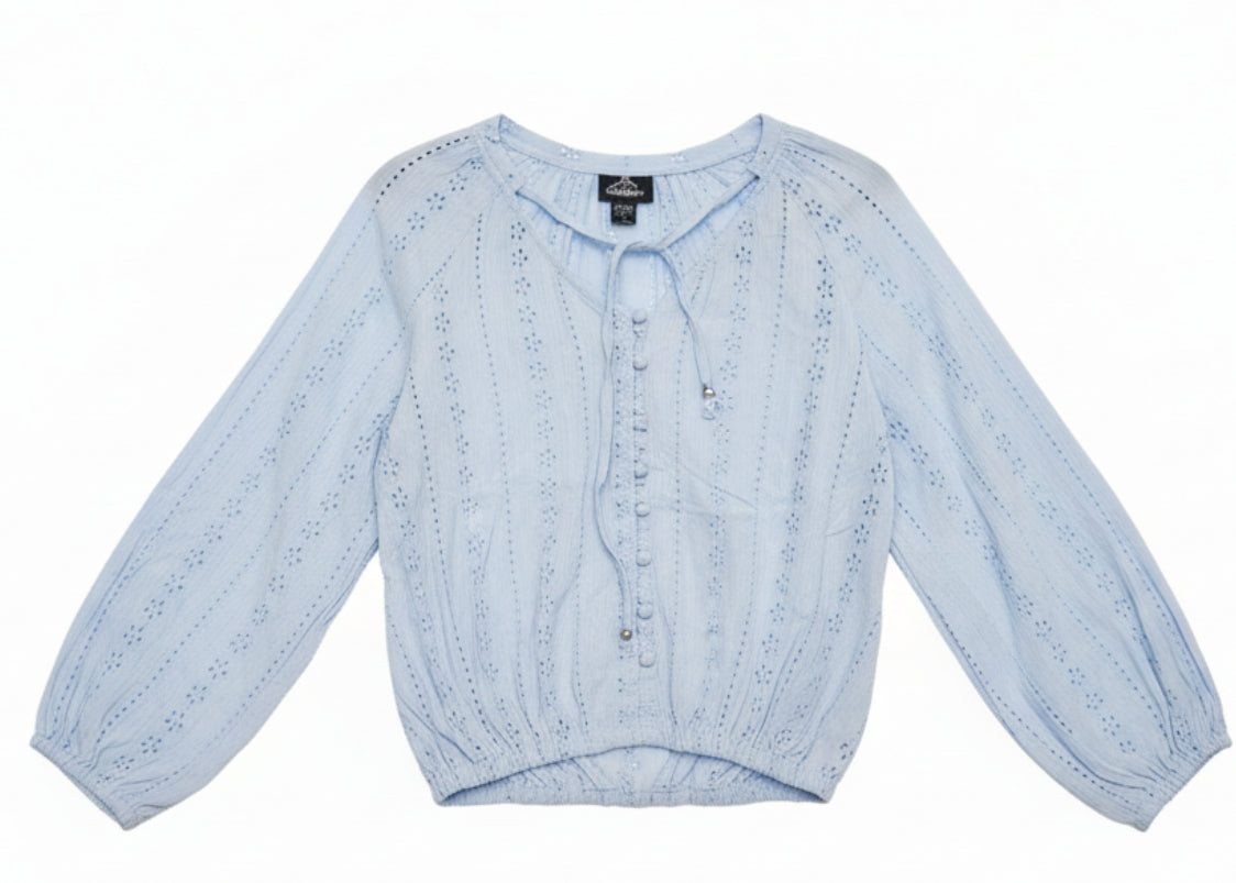 Light blue blouse with lace details on a wooden surface