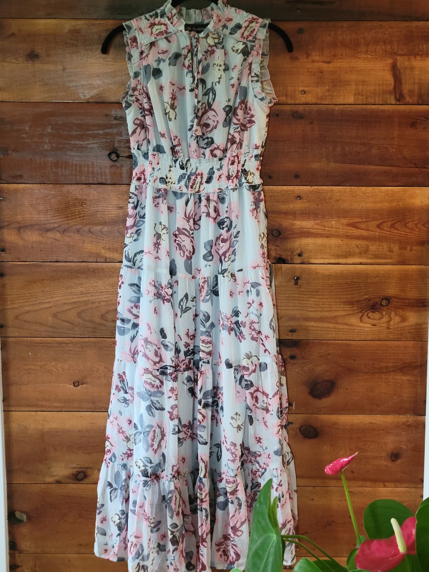 Floral dress on a wooden surface with a plant in the corner