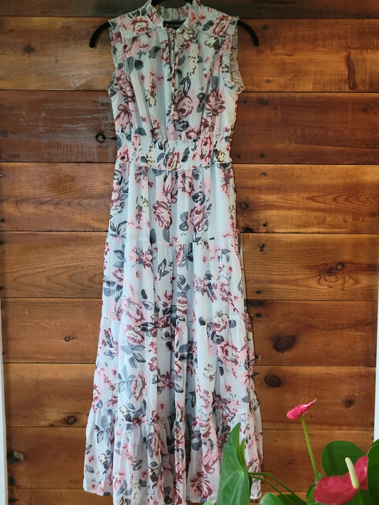 Floral dress on a wooden surface with a plant in the corner