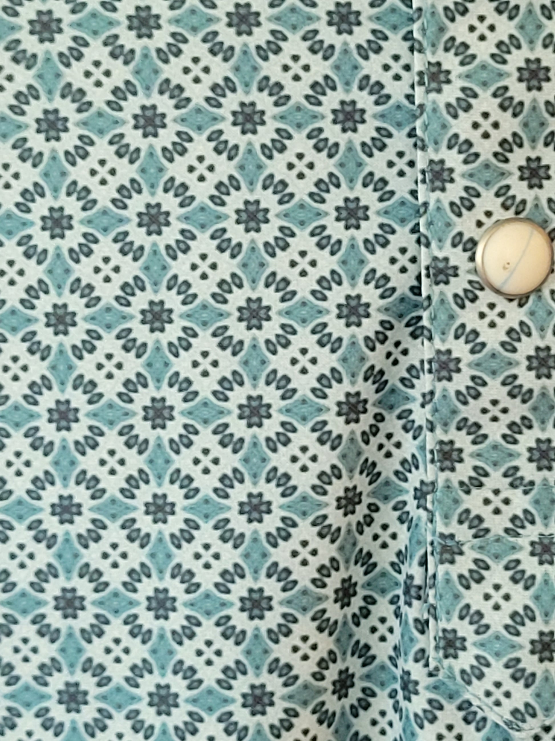 Patterned fabric with a geometric design in blue and green tones.