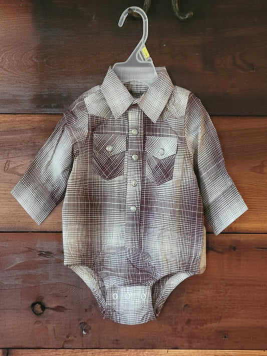 Plaid baby outfit on a wooden surface