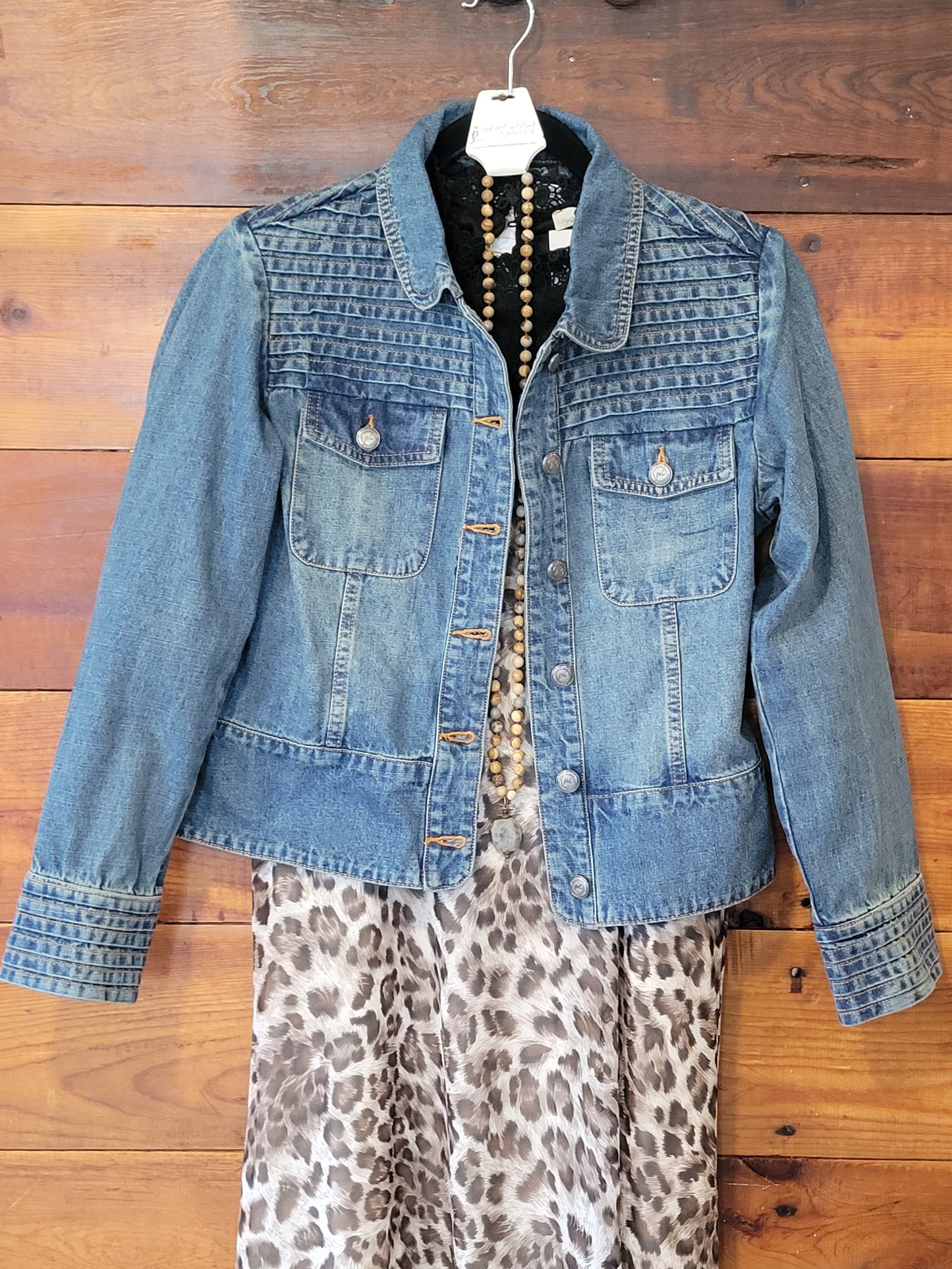 Blue denim jacket on a wooden floor with leopard print fabric partially visible