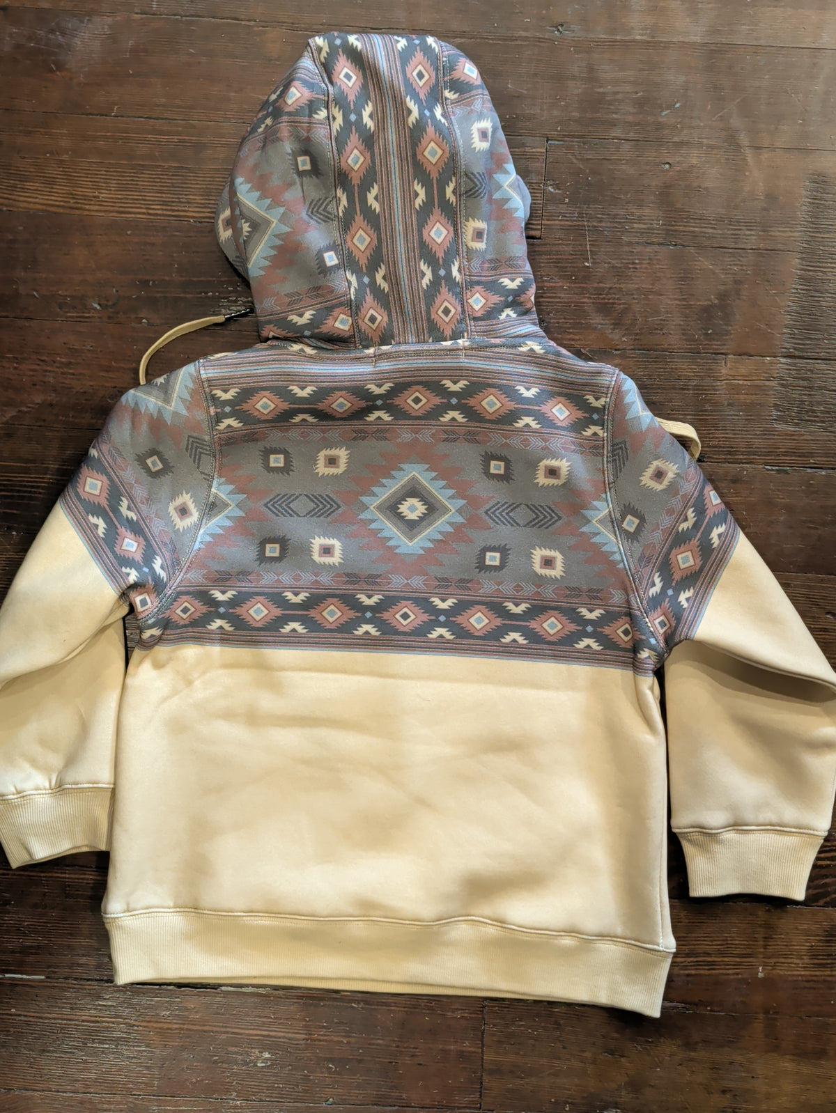 Back view of the boys cream fleece hoodie with a Southwestern print hood and shoulder yoke, ribbed cuffs, and ribbed hem