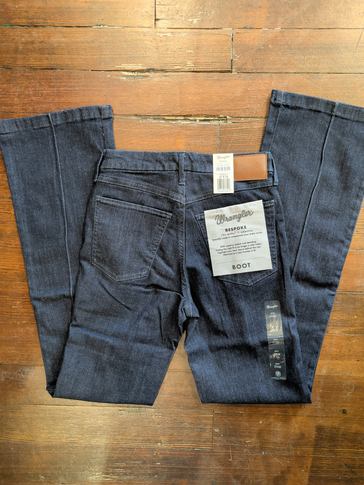 Back flat lay of Wrangler Bespoke Camryn bootcut jeans showing rear pockets, waistband patch and product tags.