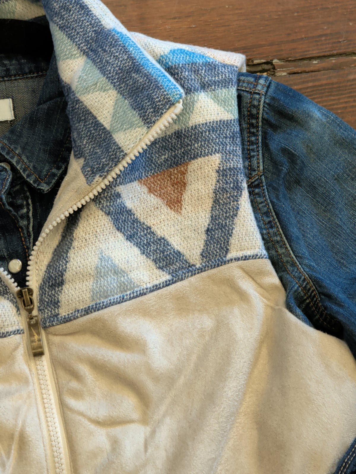 Close-up of Cream Two Tone Vest showing the geometric stand collar, patterned yoke, and front zipper.