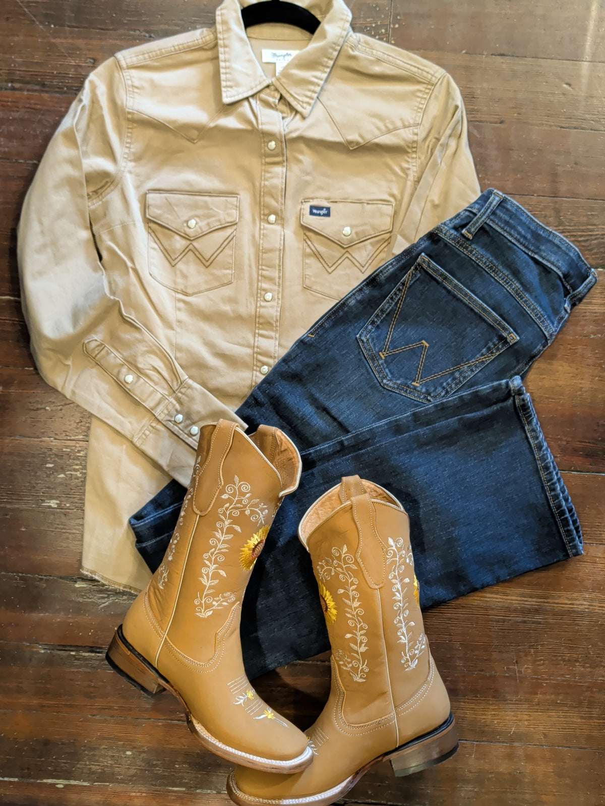 Wrangler Rawhide snap shirt paired with dark denim and tan floral-embroidered Western boots.